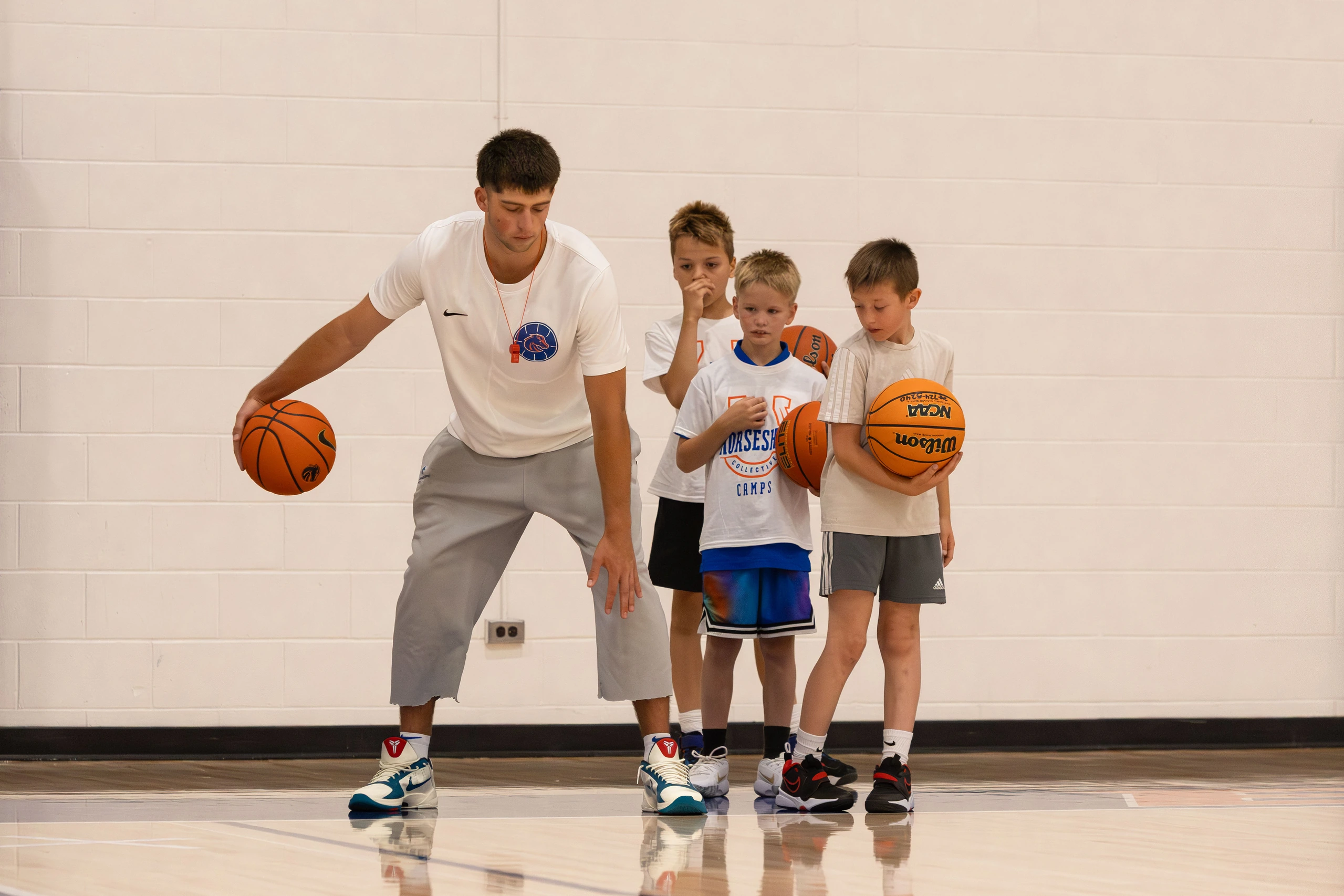 Pearson, a Boise State basketball forward, demonstrating a dribble to campers