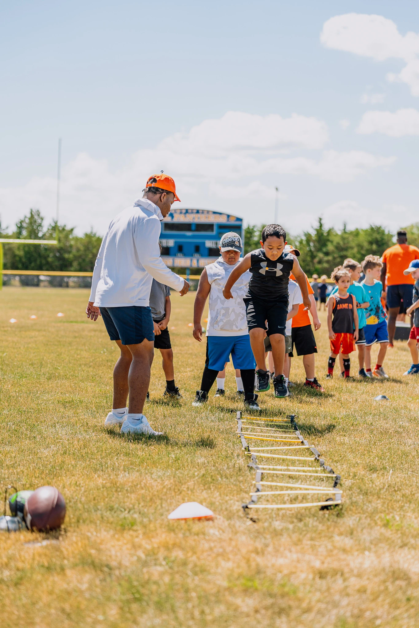Reggie, a University of Illinois running back, leading a youth football ladder drill